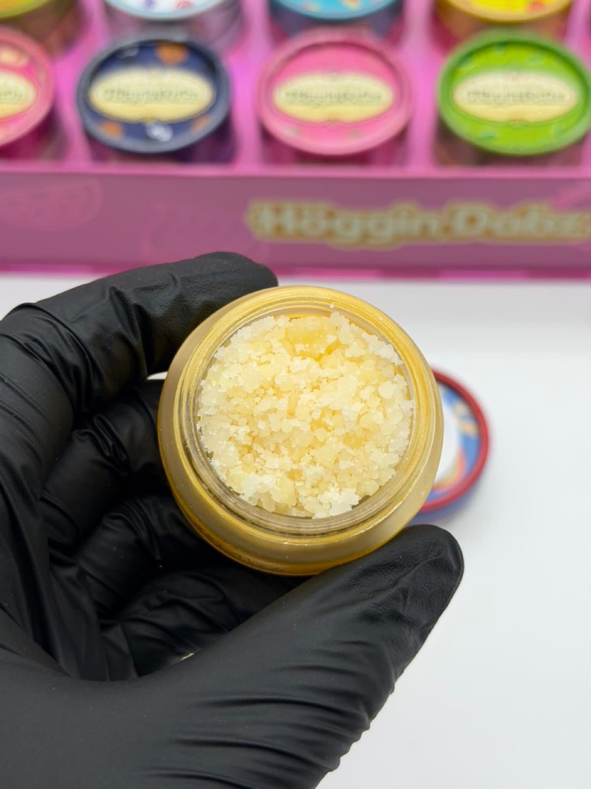 Open jar of white sugar held over the display